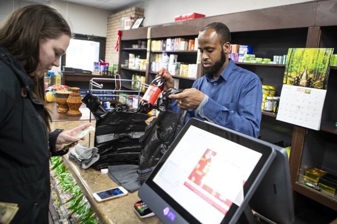 Abdiweli Yusuf, right, rings up items for Joslyn Pappadackis in Amin Grocery in downtown Willmar on Thursday, March 9, 2023.Macy Moore / West Central Tribune