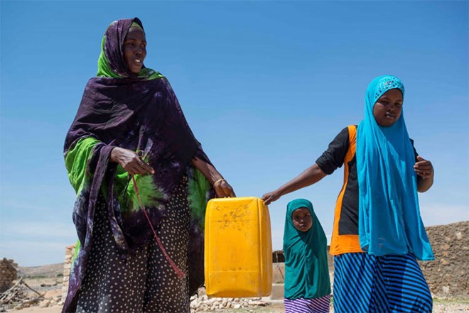 Meymun Suleiman, a resident of Rabaable village, fetches water with the help of her daughters. The village’s well was recently rehabilitated by UNICEF, and because of this, some families decided to stay although many left after their livestock died because of the drought. ©UNICEF Somalia/2016/Sebastian Rich.