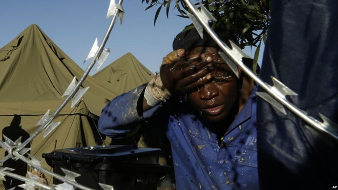 FILE - A man washes his face outside a shelter for displaced foreigners in east of Johannesburg, South Africa, April 21, 2015.