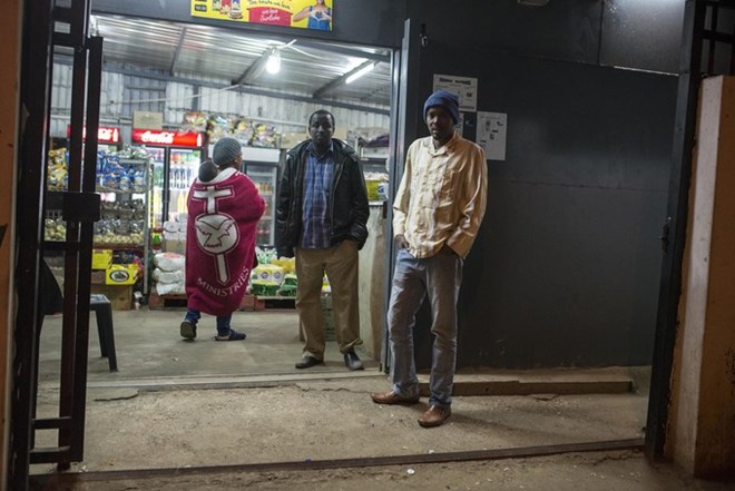 Somali shopkeepers outside their spaza shop in Pretoria West. A feeling of fear and anxiety is prevalent in this immigrant community after shops were looted and Somali nationals attacked during the Tshwane riots.