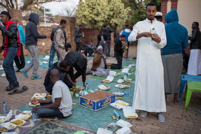 Somali immigrants eat in safety in a mosque courtyard.
