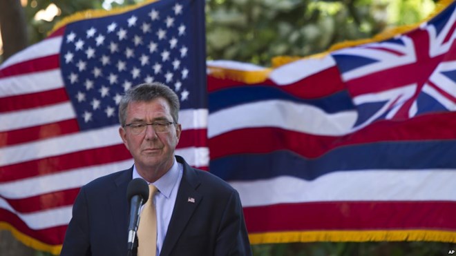 With the U.S. and Hawaii flags fluttering in the background, Defense Secretary Ash Carter speaks at a press conference during a defense ministers meeting of ASEAN, in Hawaii.