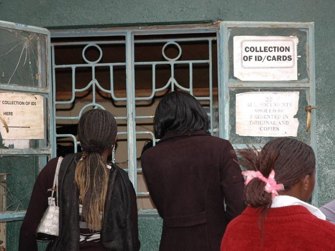 A file photo of people lined up collect their national identification cards.