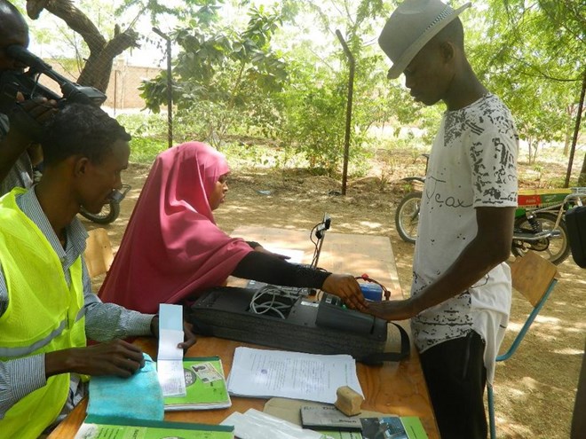 Clerks register a voter at Young Muslim Secondary School in Garissa town / STEPHEN ASTARIKO