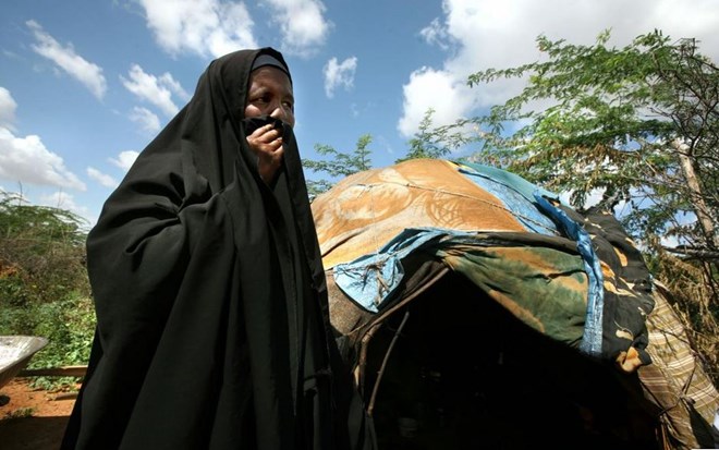 A refugee woman from Imey, a town in the Gode zone of Ethiopia's Somali Region, stands outside her makeshift home in Dadaab refugee camp in northern Kenya. She and her children fled to Kenya after her husband was killed by Ethiopian forces in December 2007.  © Evelyn Hockstein