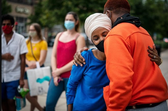 Rep. Ilhan Omar greeted a young voter outside the Dinkytown Target near the University of Minnesota campus in Minneapolis on Tuesday. LEILA NAVIDI – STAR TRIBUNE