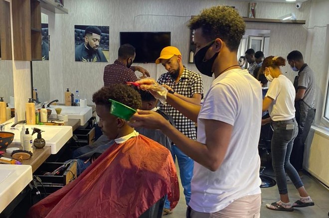 Jama brought in experienced barbers from several African countries to work at his shop in Ankara, Turkey. (AA Photo)