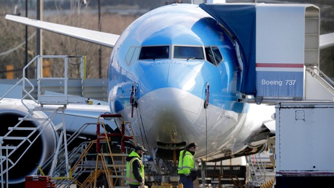 In this March 13, 2019, file photo, workers walk past a Boeing 737 MAX 8 airplane being built at Boeing Co.'s Renton Assembly Plant in Renton, Wash. (AP Photo/Ted S. Warren, File)