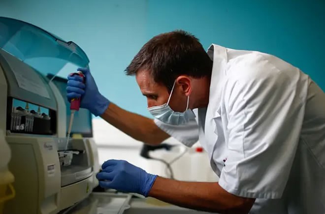 A technician scans test tubes containing live samples of the coronavirus disease at the Robert Ballanger hospital near Paris, France on April 30, 2020. Gonzalo Fuentes/Reuters