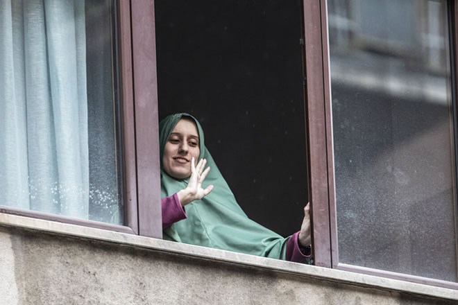 Silvia Romano waves from a window of her home, in Milan, May 11.- LUCA BRUNO – ASSOCIATED PRESS