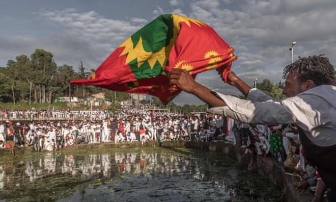A man waves an Oromo flag as people from the community gather in Addis Ababa in October 2019, on the eve of Irreecha, their thanksgiving festival. Photograph: Yonas Tadesse/AFP