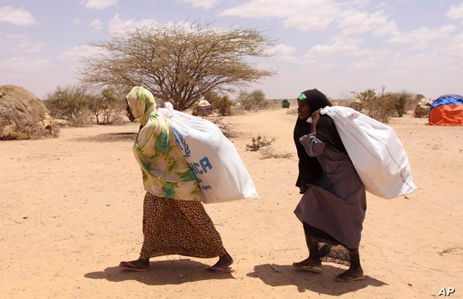 Southern Somali women carry food aid donations from the UNHCR, as they make their way to their refugee camp in Dollow, Somalia, Tuesday. Aug. 30, 2011. Despite the drought and famine, refugees in Somalia are celebrating the Muslim holiday of Eid al-