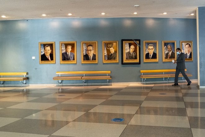 A man walk past portraits of former United Nations Secretary-Generals, Monday, Sept. 21, 2020 at United Nations headquarters. In 2020, which marks the 75th anniversary of the United Nations, the annual high-level meeting of world leaders around the U.N. General Assembly will be very different from years past because of the coronavirus pandemic. Leaders will not be traveling to the United Nations in New York for their addresses, which will be prerecorded. Most events related to the gathering will be held virtually. No access to world leaders on the U.N. grounds will be possible, therefore, and access to most anything will be extremely curtailed. (AP Photo/Mary Altaffer)