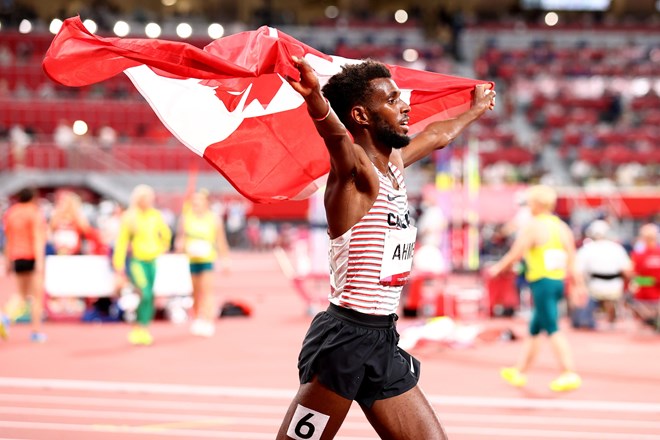 Silver medalist Mohammed Ahmed of Canada celebrates with his national flag. ANDREW BOYERS/REUTERS