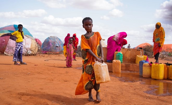 Hibo, aged 10, carries water in a jerrycan to her temporary house at Kaharey IDP camp in Dollow, Somalia. “We left our home in Guriel and walked for 10 days to reach Kaharey camp," she says. Four failed rains back-to-back have left more than 1.8 million children suffering life-threatening severe acute malnutrition. [Fazel/UNICEF]
