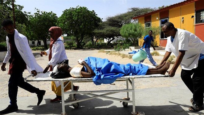 Paramedics carry an unidentified man injured in the explosion in Afgoye in Somalia [Feisal Omar/Reuters]