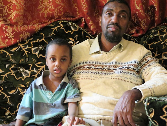 Adam Aded, right, says an FBI SWAT team went overboard Friday morning when agents came to arrest his older son Khaalid Adam Abdulkadir for allegedly threatening the FBI on Twitter. Aded says his 2-year-old son, who was present during the event, has been vomiting and hasn't been sleeping well. Mukhtar Ibrahim | MPR News