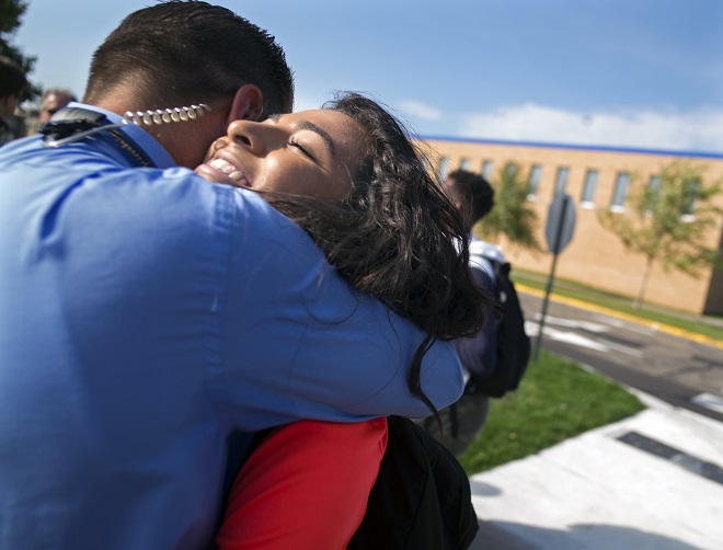 At Columbia Heights H.S., students Sherouk Mohamed,17,(orange), walked out in solidarity against a school board member's anti-muslim comments. Principal Dan Wroblewski gave her a hug and came out to lead the students back to class. He also led the walkout in solidarity with the students. (RICHARD TSONG-TAATARII)