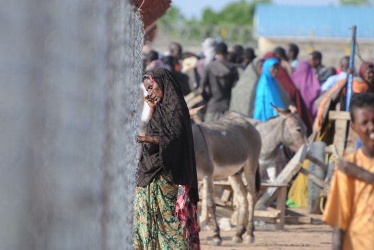 The camp grew quickly as Somalia’s crisis worsened. Although the refugees remain connected to the outside world through cellphones and spotty internet service, they are trapped, forbidden from travelling anywhere except back home. Here, a woman talks on a cellphone at a distribution centre, where refugees come every 15 days to get food rations.