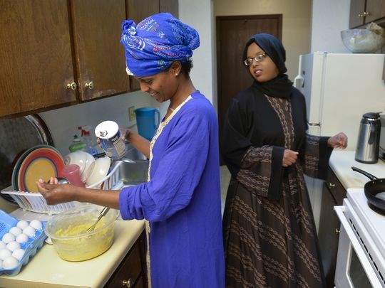 Ayan Omar, left, prepares a type of crepes called malawah as her sister, Faisa Omar, 17, heats the pan Tuesday, June 7. Each night of Ramadan all the family members who live nearby come to eat together, and there is always at least one guest. (Photo: Kimm Anderson, kanderson@stcloudtimes.com)