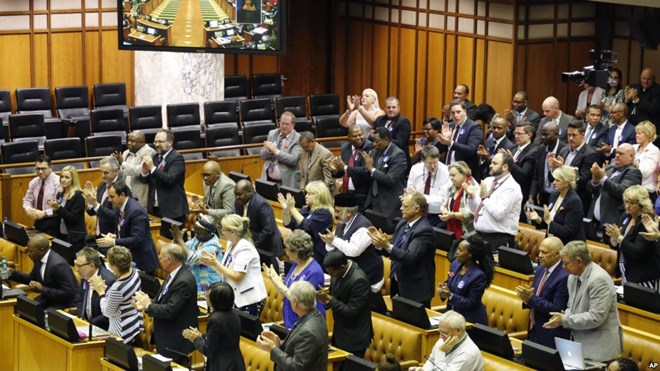 South African DA, Democratic Alliance party leader, Mmusi Maimane, far left, is applauded by his party members after he called for a motion to remove South African President Jacob Zuma as President at Parliament in Cape Town, South Africa, Nov. 10, 2016.