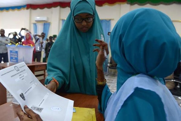 A Somali polling agent (right) explains the voting procedure to a voter before she casts her ballot in Baidoa. Somalia is in the process of selecting a new parliament, upper house and president in a limited franchise election that involves 14,000 delegates from all regional states, including Galmudug and Puntland. PHOTO | SIMON MAINA | AFP