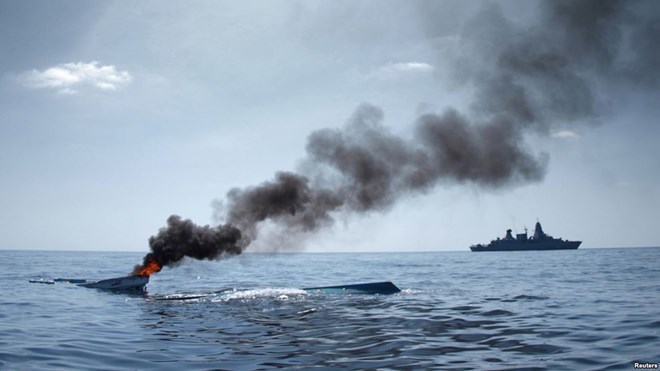 FILE - As part of the EU Naval Force Somalia, the German Frigate 'Hamburg' patrols after destroying two fishing boats (L) which were discovered floating keel side up in open waters off the coast of Somalia, August 15, 2011.