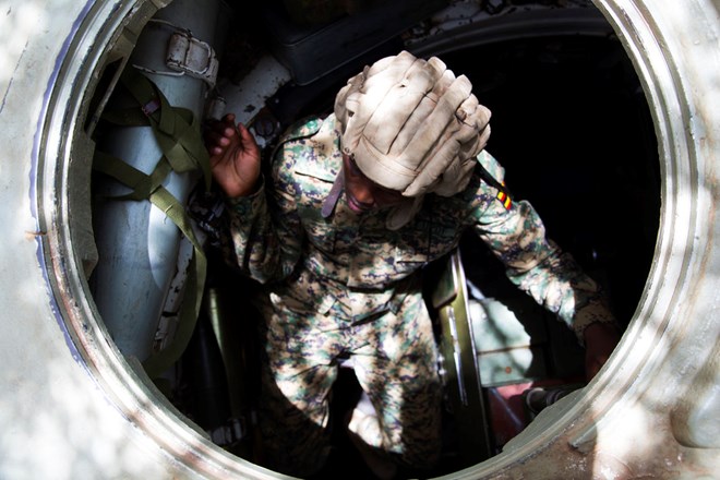 Tank gunner Lt. Cpl. Lehi Chebet climbs into the turret of her T-55. (CHRISTINA GOLDBAUM | FOREIGN POLICY)