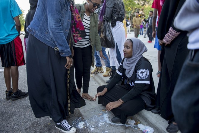 A woman sits on a curb after being sprayed by officers on Saturday, Sept. 10, 2016 in the Cedar-Riverside neighborhood.
Photo by: Easton Green