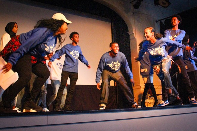 Representing the colors of the Somali flag, a team dressed in blue competes on stage to the amusement of the audience. The youth-organized event raised money for drought relief in Somalia. (Photo by Damme Getachew.)