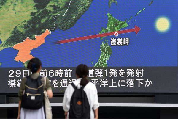 Pedestrians watch news on a huge screen displaying a map of Japan (right) and the Korean Peninsula, in Tokyo on August 29, 2017, following a North Korean missile test that passed over Japan. PHOTO | TOSHIFUMI KITAMURA | AFP