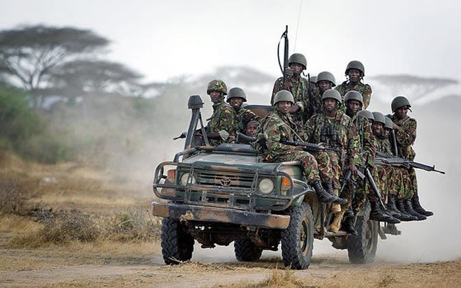 Kenyan army soldiers ride on a vehicle at their base in Tabda, inside Somalia