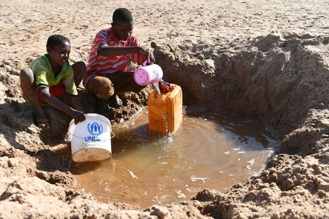 A man and a boy fetch water from a hole in a riverbed near Doolow, a border town with Ethiopia, Somalia, March 20, 2017. Xinhua News Agency/Getty Images