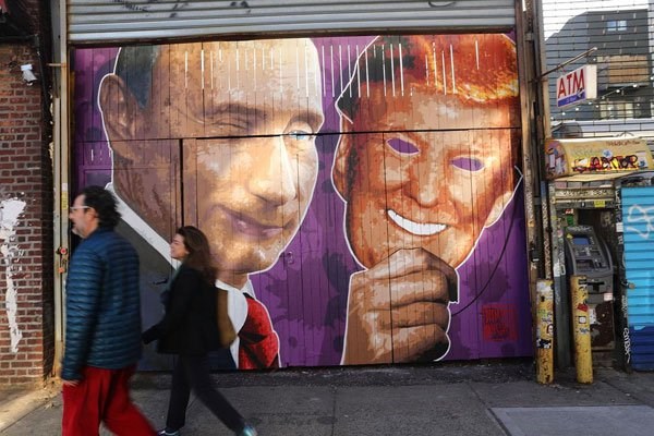 A mural depicting a winking Vladimir Putin taking off his Donald Trump mask is painted on a storefront outside of the Levee Bar in Brooklyn on February 25, 2017 in New York City. PHOTO | SPENCER PLATT | AFP