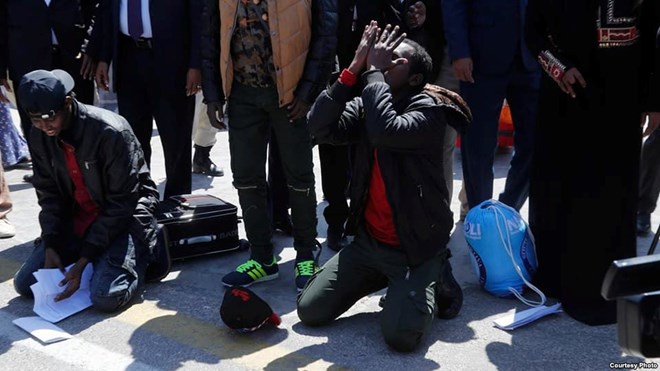 Somali migrants kneel and pray after arriving back in the Somali capital, Mogadishu, Feb. 17, 2018. (Somali Ministry of Information)