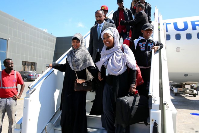 Somali migrants disembark from a plane upon arrival from Libya to be repatriated in their country at Mogadishu International Airport, Feb. 17, 2018. (H.K. Qoyste/VOA)