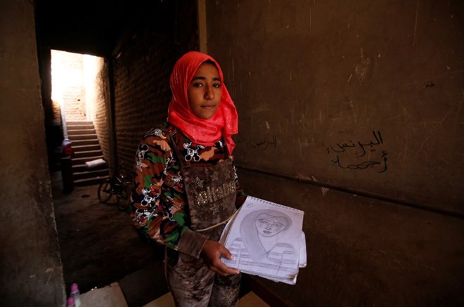 Amany Shamekh, 16, holds her drawing and poses for a photograph at her home in Awlad Serag village of Assiut Governorate, south of Cairo, Egypt, February 8, 2018. Picture taken February 8, 2018. REUTERS/Hayam Adel