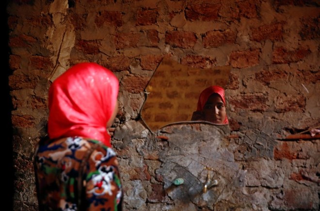 Amany Shamekh, 16, looks at herself in the mirror at her home in Awlad Serag village of Assiut Governorate, south of Cairo, Egypt, February 8, 2018. Picture taken February 8, 2018. REUTERS/Hayam Adel